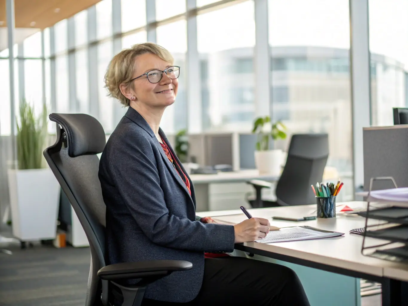 A focused UK leader participating in a one-on-one coaching session, discussing strategic goals and action plans in a modern office setting.